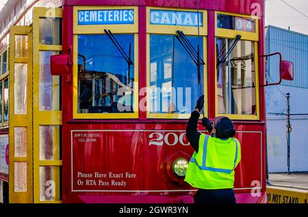 Ein Straßenbahnbetreiber von New Orleans hebt am 14. November 2015 in New Orleans, Louisiana, den Trolley-Pol am Ende der Canal Street-Route an. Stockfoto