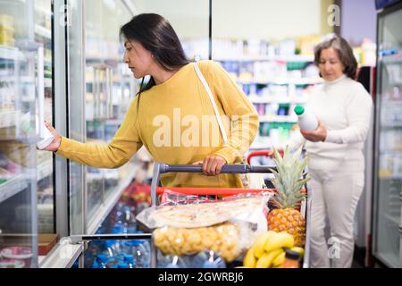 Weibliche Shopper wählt Milchprodukte im Supermarkt Stockfoto
