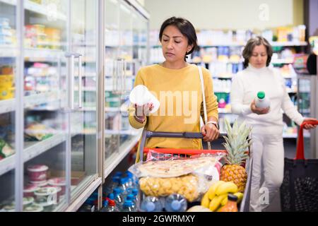 Weibliche Shopper wählt Milchprodukte im Supermarkt Stockfoto