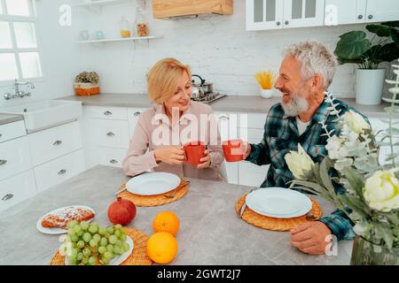 Das Paar frühstückte zu Hause mit Kaffee und Obst Stockfoto