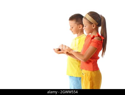 Niedliche kleine Kinder mit Schnecken auf weißem Hintergrund Stockfoto