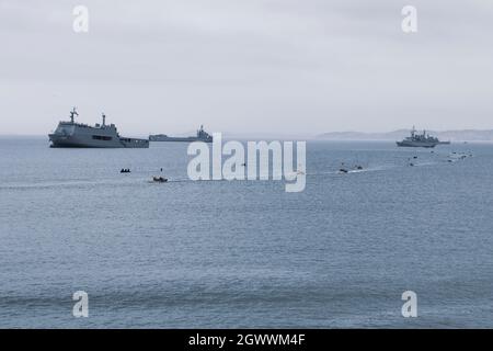 Peruanische und mexikanische Marineinfanteristen betreiben amphibische gepanzerte Fahrzeuge und MK-V-Boote während einer amphibischen Landung im Rahmen von UNITAS LXII, 2. Oktober 2021. UNITAS ist die am längsten laufende maritime Übung der Welt. Dieses Jahr wird es von Peru ausgerichtet und bringt multinationale Streitkräfte aus zwanzig Ländern zusammen, darunter 29 Schiffe, vier U-Boote und zwanzig Flugzeuge, die vor der Küste von Lima und im Dschungel von Iquitos operieren. Die Übung schult die Kräfte, um gemeinsame Seeoperationen durchzuführen, und konzentriert sich auf die Stärkung von Partnerschaften und die Verbesserung der Interoperabilität und Fähigkeiten Stockfoto