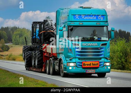 Kundenspezifischer Scania Sattelauflieger von K. Koivula transportiert Logset Forwarder als Breitlast auf der Straße 52 im Herbst. Salo, Finnland. 24. September 2021. Stockfoto