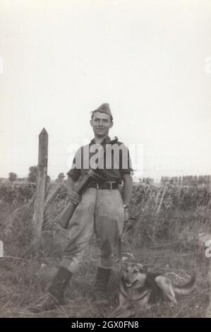 Vintage / Retro Armee / Militär PPSh-41 Serie 5. Ein Soldat mit einem Hund ( Deutscher Schäferhund ) posiert mit seinem sowjetischen Maschinengewehr auf dem Feld herum in den 1950er Jahren. Er stammt aus Osteuropa, möglicherweise aus Ungarn. Papasha Design von Georgy Shpagin. Der PPSh-41 war von 1941 bis 1960 in Betrieb Quelle: Originalfoto Stockfoto