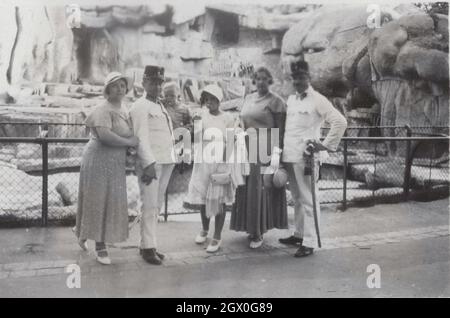 Seltenes Original-Vintage-Foto: Zwei hochrangige Militäroffiziere aus dem Österreich-Ungarn-Imperium / der Monarchie (die sie in zeremoniellen Uniformen mit Schwert und Hut tragen) und ihre Familie besuchen den Zoo in Budapest Ungarn. Zeitraum: 1910er Jahre Quelle: Originalfoto Stockfoto