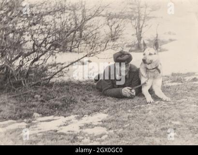 Vintage / Retro Armee / Militär deutscher Schäferhund Serie 2. Ein Soldat posiert mit seinem Hund ( Deutscher Schäferhund ) auf dem Feld um in den 1950er Jahren. Er kommt aus Osteuropa, möglicherweise aus Ungarn. Quelle: Originalfoto Stockfoto