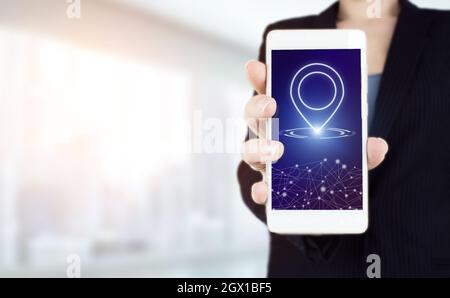 GPS-Karte, Adressposition auf mobilen Apps anheften. Handgriff weißes Smartphone mit digitalem Hologramm Positionsmarkierungszeichen auf hellem verschwommenem Hintergrund Stockfoto