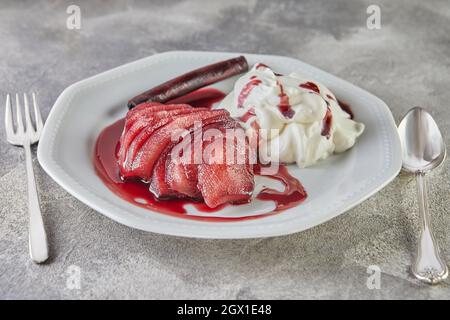 Weiße Schokoladenmousse mit Birnen in Rotwein auf Servierteller Stockfoto