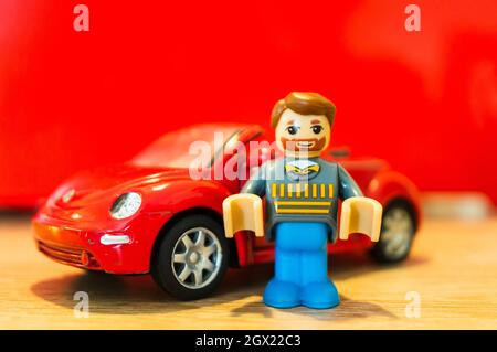 POZNAN, POLEN - 15. Feb 2019: Ein lego Spielzeug eines Mannes mit Bart, der neben seinem geparkten roten Volkswagen Beetle Cabrio steht Stockfoto