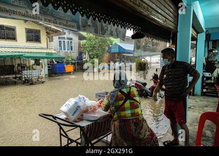 Nonthaburi, Thailand. Oktober 2021. Man sieht die Menschen, die auf die untergetauchte Straße schauen. Thailand ist aufgrund der starken Regenfälle, der Gezeitenwelle und der Wasserabflüsse vom Chao Phraya-Staudamm nach dem Sturm von Dianmu im Land mit einer Sturmflut konfrontiert. Viele Bewohner sind jedes Jahr mit Überschwemmungen konfrontiert, aber in diesem Jahr stieg der Wasserstand sofort an und verursachte mehr Schäden als üblich. Kredit: SOPA Images Limited/Alamy Live Nachrichten Stockfoto