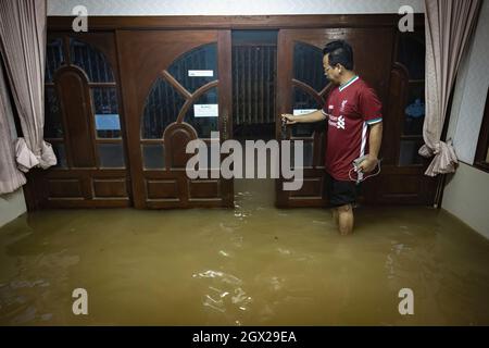 Nonthaburi, Thailand. Oktober 2021. In seinem überfluteten Haus wird ein Mann gesehen. Thailand ist aufgrund der starken Regenfälle, der Gezeitenwelle und der Wasserabflüsse vom Chao Phraya-Staudamm nach dem Sturm von Dianmu im Land mit einer Sturmflut konfrontiert. Viele Bewohner sind jedes Jahr mit Überschwemmungen konfrontiert, aber in diesem Jahr stieg der Wasserstand sofort an und verursachte mehr Schäden als üblich. Kredit: SOPA Images Limited/Alamy Live Nachrichten Stockfoto