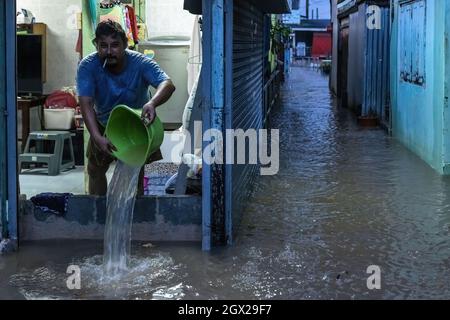 Nonthaburi, Thailand. Oktober 2021. Ein Mann wird gesehen, wie er in seinem Haus Flutwasser abpumpt. Thailand ist aufgrund der starken Regenfälle, der Gezeitenwelle und der Wasserabflüsse vom Chao Phraya-Staudamm nach dem Sturm von Dianmu im Land mit einer Sturmflut konfrontiert. Viele Bewohner sind jedes Jahr mit Überschwemmungen konfrontiert, aber in diesem Jahr stieg der Wasserstand sofort an und verursachte mehr Schäden als üblich. Kredit: SOPA Images Limited/Alamy Live Nachrichten Stockfoto