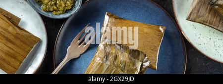 Tamale Panorama, traditionelles Gericht der mexikanischen Küche, verschiedene Stuffings in grünen Blättern eingewickelt. Hispanische Küche, von oben geschossen Stockfoto