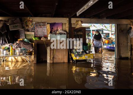 Nonthaburi, Thailand. Oktober 2021. Eine Frau steht in einem überfluteten Bereich. Thailand ist aufgrund der starken Regenfälle, der Gezeitenwelle und der Wasserabflüsse vom Chao Phraya-Staudamm nach dem Sturm von Dianmu im Land mit einer Sturmflut konfrontiert. Viele Bewohner sind jedes Jahr mit Überschwemmungen konfrontiert, aber in diesem Jahr stieg der Wasserstand sofort an und verursachte mehr Schäden als üblich. (Foto: Phobthum Yingpaiboonsuk/SOPA I/Sipa USA) Quelle: SIPA USA/Alamy Live News Stockfoto