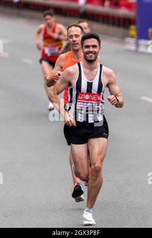 Craig Ruddy beim Virgin Money London Marathon 2021 in Tower Hill, London, Großbritannien, an der Spitze einer Gruppe von Clubläufern Stockfoto