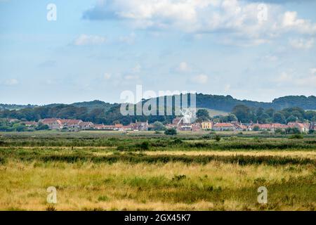 Blick auf Cley neben dem Sea Village mit Cley Windmill vom Wanderweg in Blakeney Freshes, Norfolk, England. Stockfoto