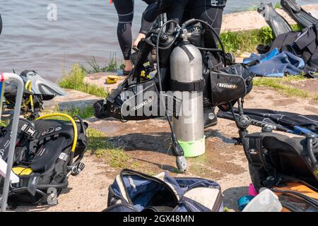 Tauchausrüstung mit Sauerstofftank im Zentrum befindet sich an einem sonnigen Sommertag am Ufer. Stockfoto