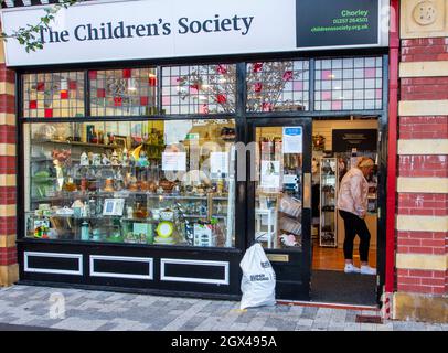 Gespendete Gegenstände vor dem Wohltätigkeitsgeschäft der „Children's Society“ in Chorley, Lancashire, Großbritannien Stockfoto