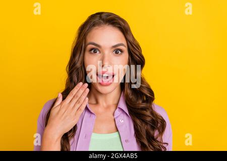 Portrait von attraktiven erstaunt fröhlich wellig-haarige Mädchen gute Laune Reaktion isoliert über hellen gelben Hintergrund Stockfoto