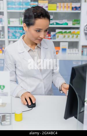 Apotheker in weißer Schicht mit Computer in der Apotheke Stockfoto