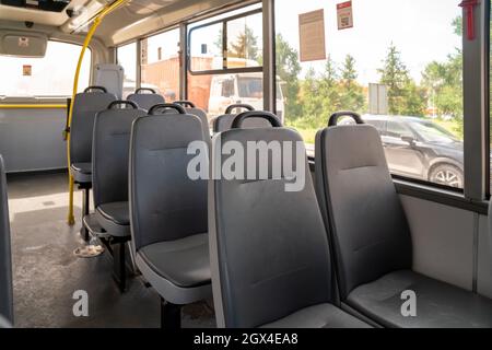 Salon eines öffentlichen Stadtbusses mit Ledersitzen ohne Passagiere.