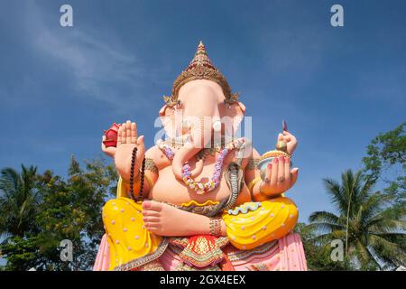 Malerische große Statue von Lord Ganesha, hellblauer Himmel und tropischer Garten im Hintergrund. Narathiwat, Südthailand. Stockfoto