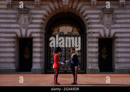 Ein Soldat des 1. Bataillons Coldstream Guards (links) und ein Soldat des 1. Regiments Royal Canadian Horse Artillery (rechts) nehmen am Wachwechsel auf dem Vorplatz des Buckingham Palace, London, Teil. Bilddatum: Montag, 4. Oktober 2021. Stockfoto