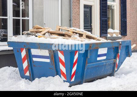 Holländischer Abfallcontainer in einer alten Straße auf einer Hausrenovierungsstelle im Winter Stockfoto