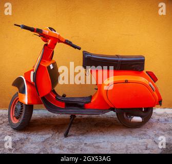 Orange Vespa, berühmtes italienisches Motorrad, das in der Straße von Linosa geparkt ist Stockfoto