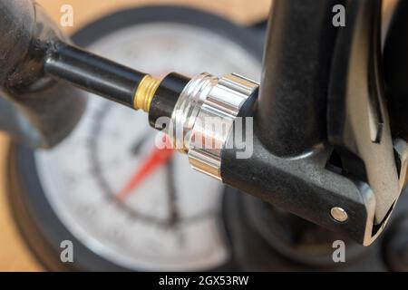 Nahaufnahme einer Pumpe mit Manometer, das Luft in ein Ventil des Innenrohrs bläst Stockfoto