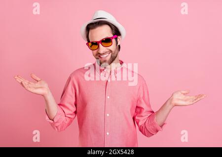 Portrait von attraktiven fröhlichen Kerl trägt Specs einladend auf Reise isoliert über rosa Pastellfarben Hintergrund Stockfoto