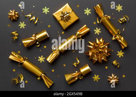 Weihnachtscracker mit glänzendem Konfetti auf farbigem Hintergrund, Draufsicht, Kopierraum. Stockfoto