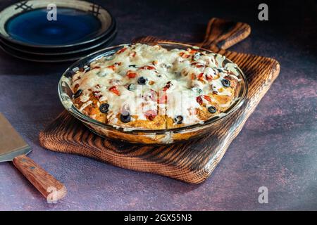 Frisch gebackene hausgemachte Pizza zerlegt das Brot auf einem Holzbrett. Stockfoto