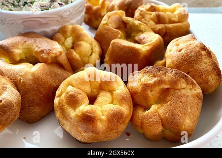 Frische Popover-Muffins werden auf einer weißen Platte serviert. Yorkshire Pudding. Selektiver Fokus Stockfoto