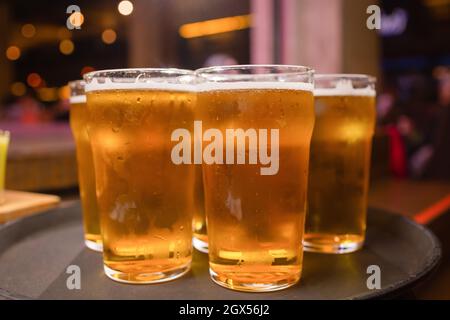 Der Kellner servierte Gläser kaltes Bier auf dem Tablett Stockfoto