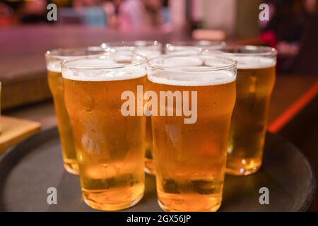 Der Kellner servierte Gläser kaltes Bier auf dem Tablett Stockfoto