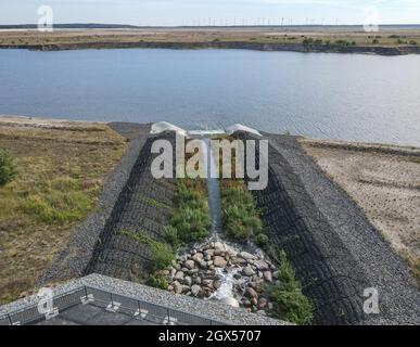 01. Oktober 2021, Brandenburg, Cottbus: Die Einlaufstruktur für das Wasser der aufstrebenden Cottbuser Ostsee, der ehemaligen Braunkohlemine Cottbus-Nord (Luftaufnahme mit Drohne). Auch die Landmasse darüber wird in den nächsten Jahren im Wasser verschwinden. Mitte April 2019 begann die Überschwemmung der ehemaligen Tagebaumine Cottbus-Nord. Das Energieunternehmen Lausitz Energie Bergbau AG (LEAG) lässt für das Hochwasser Wasser aus der Spree über den Hammergraben in das Tagebauloch fließen - rund 45 Millionen Kubikmeter pro Jahr sind geplant. Es wird berichtet, dass der riesige künstliche See einen Wassersurf hat Stockfoto