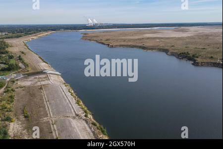 01. Oktober 2021, Brandenburg, Cottbus: Die Einlaufstruktur für das Wasser der aufstrebenden Cottbuser Ostsee, der ehemaligen Braunkohlegrube Cottbus-Nord (Luftaufnahme mit Drohne). Die Landmasse rechts auf dem Foto wird in den nächsten Jahren ebenfalls im Wasser verschwinden. Mitte April 2019 begann die Überschwemmung der ehemaligen Tagebaumine Cottbus-Nord. Das Energieunternehmen Lausitz Energie Bergbau AG (LEAG) lässt für das Hochwasser Wasser aus der Spree über den Hammergraben in das Tagebauloch fließen - rund 45 Millionen Kubikmeter pro Jahr sind geplant. Der riesige künstliche See wird gemeldet Stockfoto