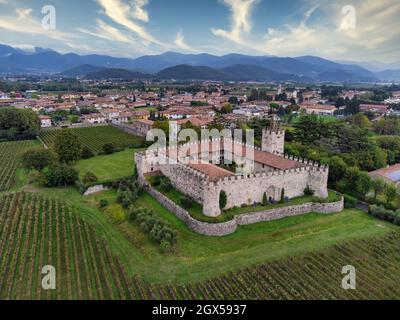 Luftaufnahme eines mittelalterlichen Schlosses umgeben von Weinbergen in der Franciacorta Region, Weintour in der Lombardei, Italien Stockfoto