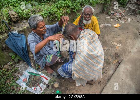 Barishal, Barishal, Bangladesch. Oktober 2021. Der Barbier schneidet einem alten Mann auf einem offenen Feld in Barishal, Bangladesch, Haare (Bildquelle: © Mustasinur Rahman Alvi/ZUMA Press Wire) Stockfoto