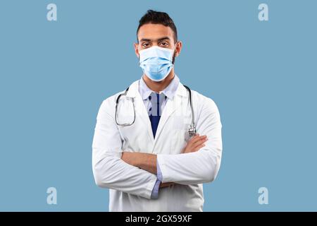 Porträt Des Arabischen Arzt Trägt Gesichtsmaske, Blauer Hintergrund Stockfoto