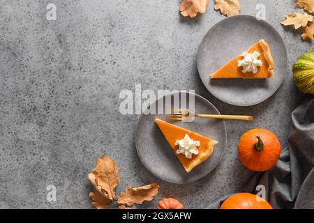 American Pumpkin Pie serviert für zwei Personen auf einem grauen Steintisch mit Platz zum Kopieren. Blick von oben. Festessen am Thanksgiving Day. Stockfoto