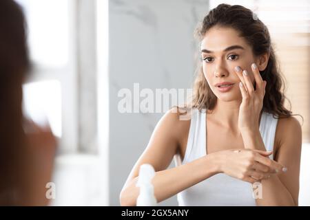 Junge Frau Macht Make-Up Anwendung Foundation Im Badezimmer Stehen Stockfoto