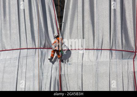 Paris, Frankreich, 4. Oktober 2021: Der Arc de Triomphe in Paris wird am Ende der Kunstinstallation der Künstler Christo und Jeanne-Claude ausgepackt, die Tausende von Touristen angezogen hat. Das Abwickeln ist auch ein Schauspiel, da Arbeiter an Seilen und in Kirschenpflücker nach und nach den Bogen enthüllen, während sie das blaue und silberne Gewebe entfernen. Anna Watson/Alamy Live News Stockfoto