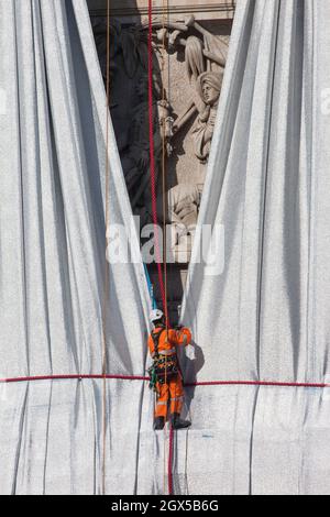 Paris, Frankreich, 4. Oktober 2021: Der Arc de Triomphe in Paris wird am Ende der Kunstinstallation der Künstler Christo und Jeanne-Claude ausgepackt, die Tausende von Touristen angezogen hat. Das Abwickeln ist auch ein Schauspiel, da Arbeiter an Seilen und in Kirschenpflücker nach und nach den Bogen enthüllen, während sie das blaue und silberne Gewebe entfernen. Anna Watson/Alamy Live News Stockfoto