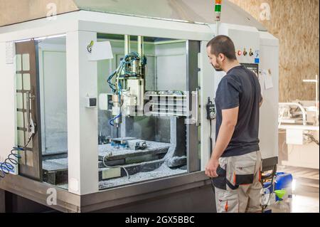 Ingenieur Arbeiter Techniker mit CNC-Fräsen Metallgravur Maschine in der Werkshalle. Stockfoto