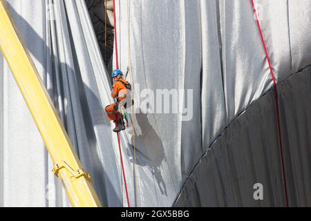 Paris, Frankreich, 4. Oktober 2021: Der Arc de Triomphe in Paris wird am Ende der Kunstinstallation der Künstler Christo und Jeanne-Claude ausgepackt, die Tausende von Touristen angezogen hat. Das Abwickeln ist auch ein Schauspiel, da Arbeiter an Seilen und in Kirschenpflücker nach und nach den Bogen enthüllen, während sie das blaue und silberne Gewebe entfernen. Anna Watson/Alamy Live News Stockfoto