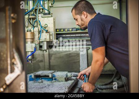 Ingenieur Arbeiter Techniker mit CNC-Fräsen Metallgravur Maschine in der Werkshalle. Stockfoto