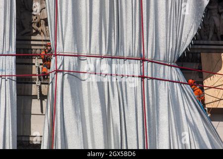 Paris, Frankreich, 4. Oktober 2021: Der Arc de Triomphe in Paris wird am Ende der Kunstinstallation der Künstler Christo und Jeanne-Claude ausgepackt, die Tausende von Touristen angezogen hat. Das Abwickeln ist auch ein Schauspiel, da Arbeiter an Seilen und in Kirschenpflücker nach und nach den Bogen enthüllen, während sie das blaue und silberne Gewebe entfernen. Anna Watson/Alamy Live News Stockfoto