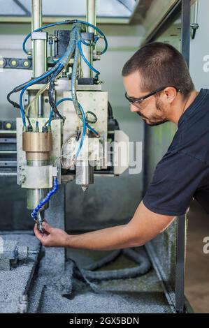 Ingenieur Arbeiter Techniker mit CNC-Fräsen Metallgravur Maschine in der Werkshalle. Stockfoto